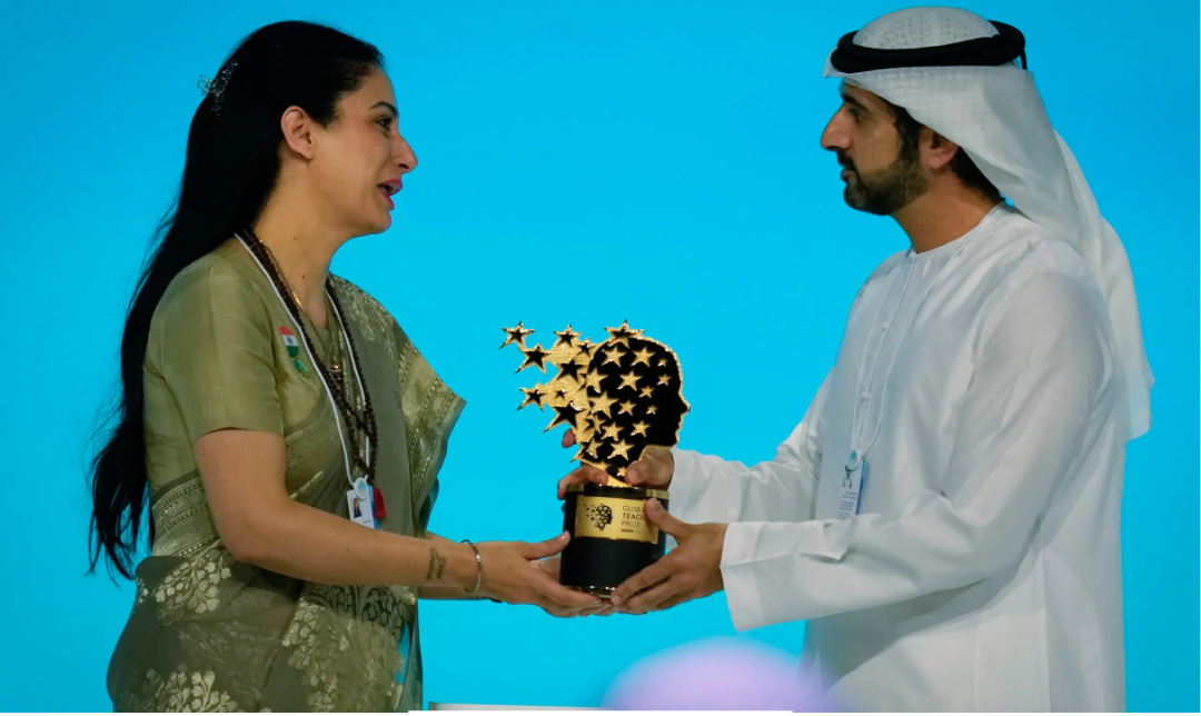 மும்பை-இர பேசும் குடிசை சுவரில் கல்விப் படைப்பைப் பார்த்து மகிழும் பிள்ளைகள் மற்றும் விருது பெற்ற ஆசிரியர் ரூபிள் நாகி.